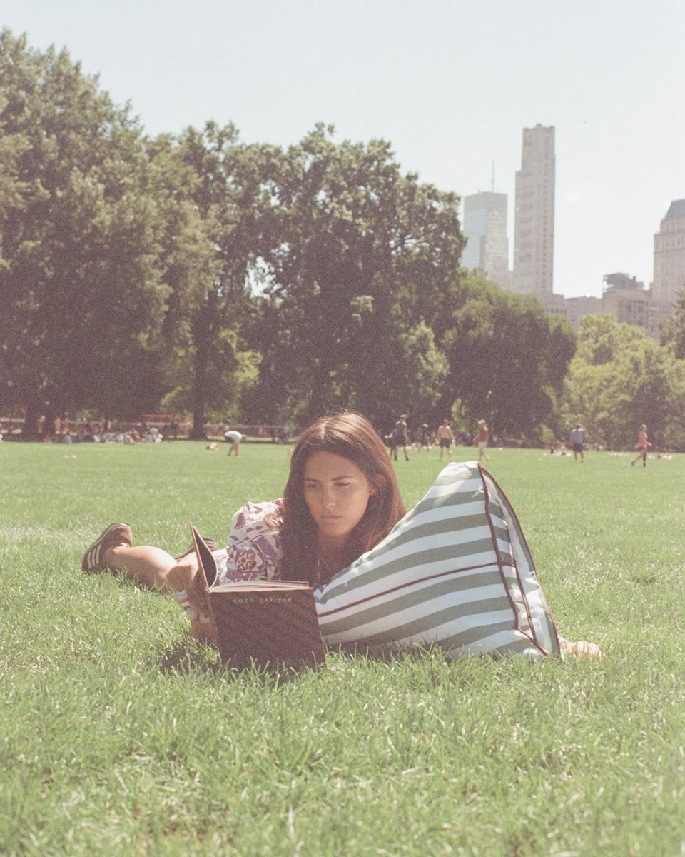Woman reading against the Tribeca backrest in Central Park