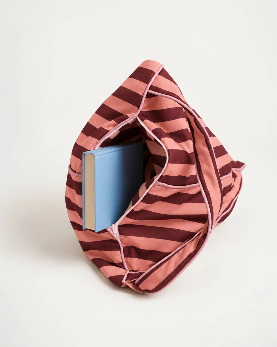 Open storage compartment of the East Hampton backrest holding a hardcover book