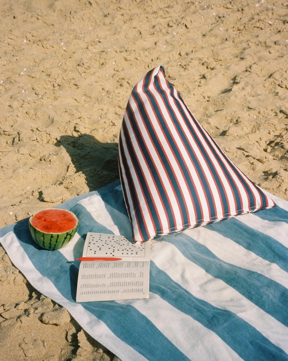Montauk backrest on a striped towel with a watermelon and a crossword