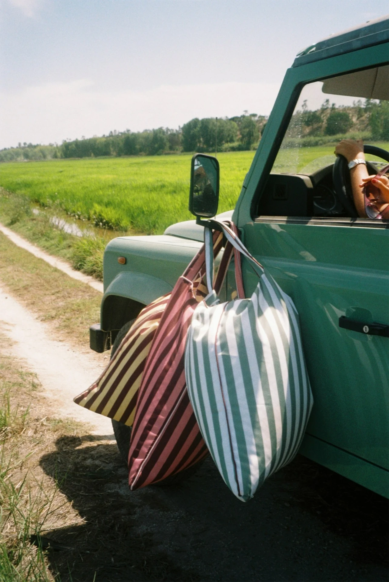 LIELOW striped bags hanging from a vintage Land Rover