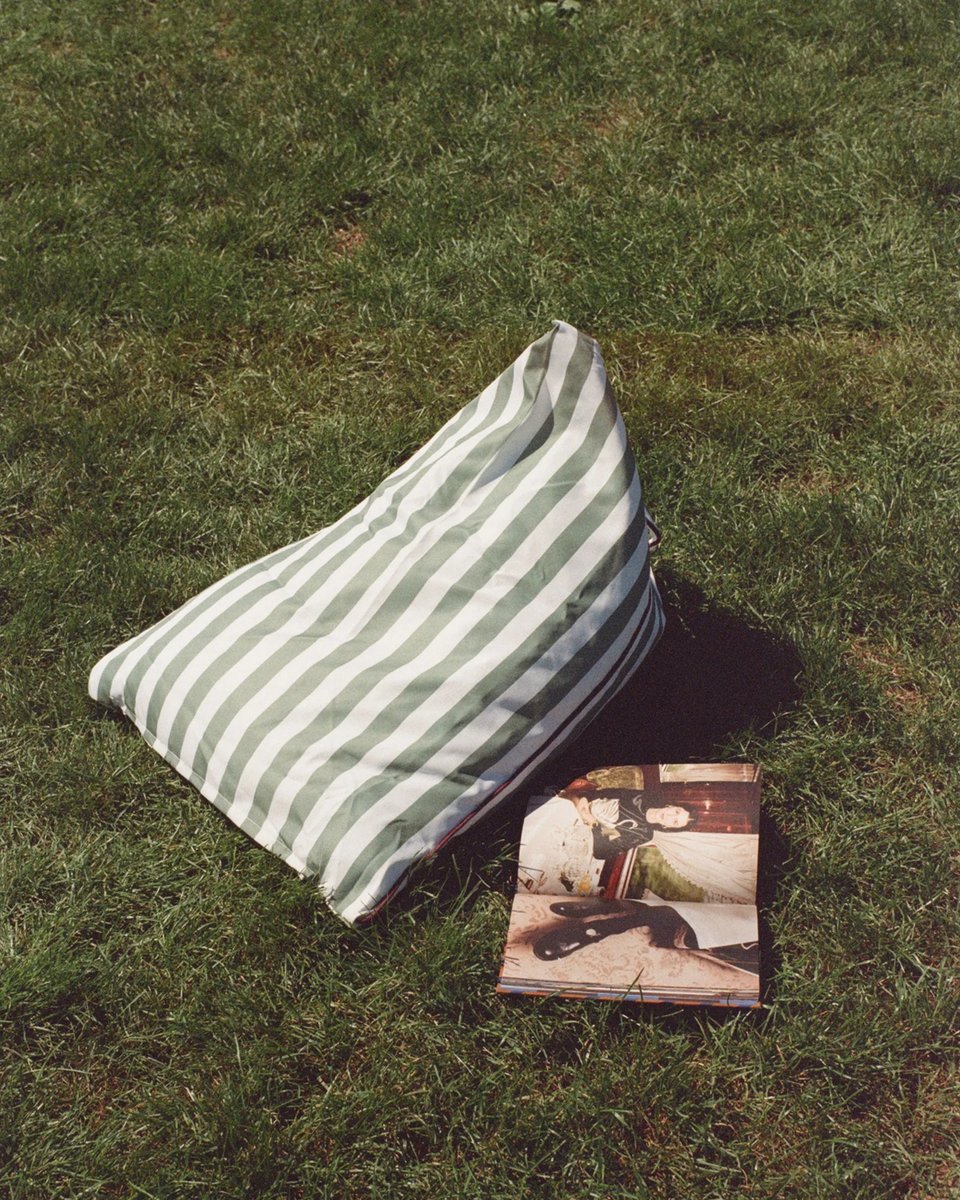 Tribeca backrest on the grass in Central Park with a magazine