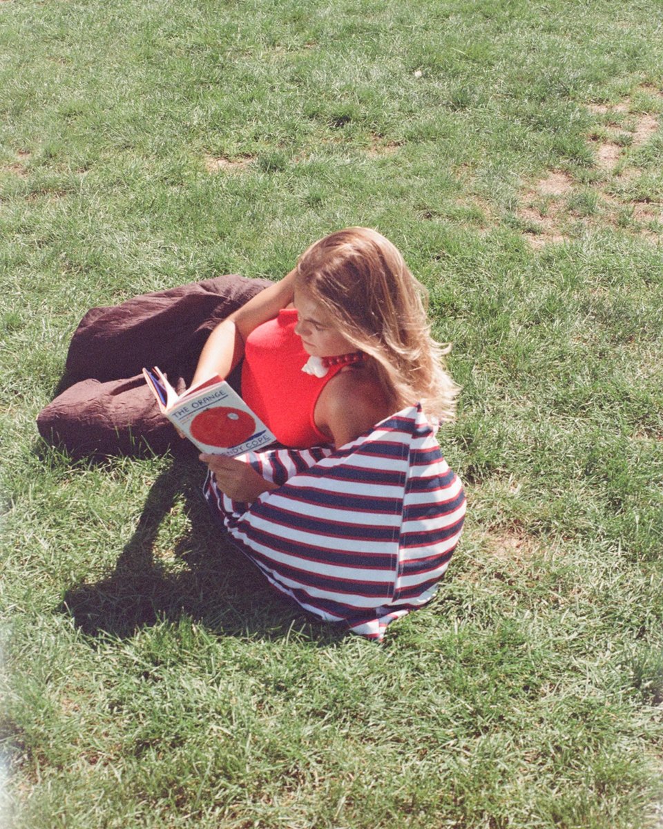 Woman reading against the Montauk backrest in Central Park