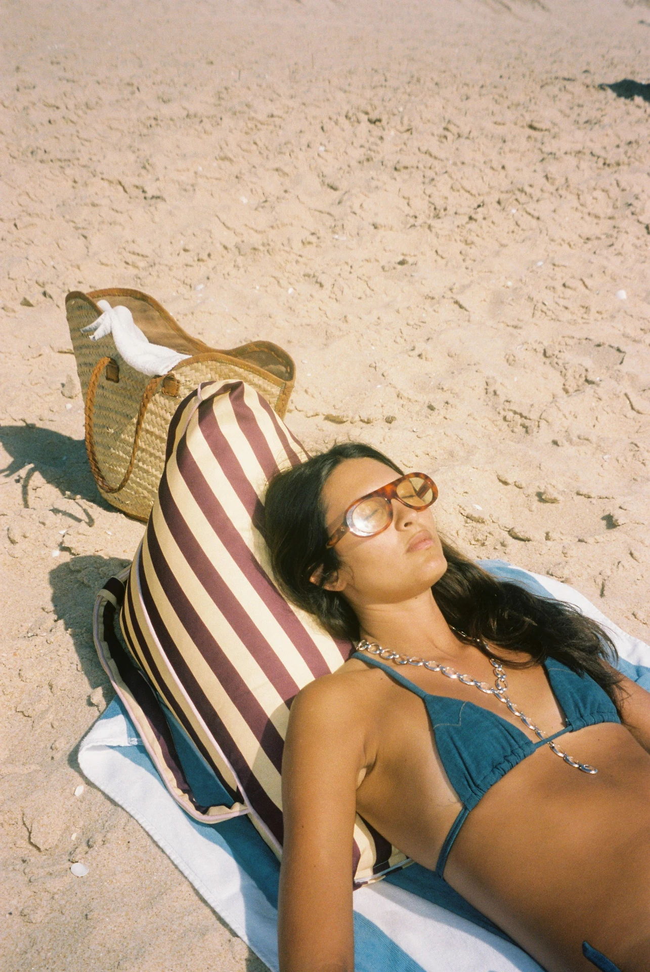 LIELOW Pier 55 — model lounging on striped bag-chair on the sand