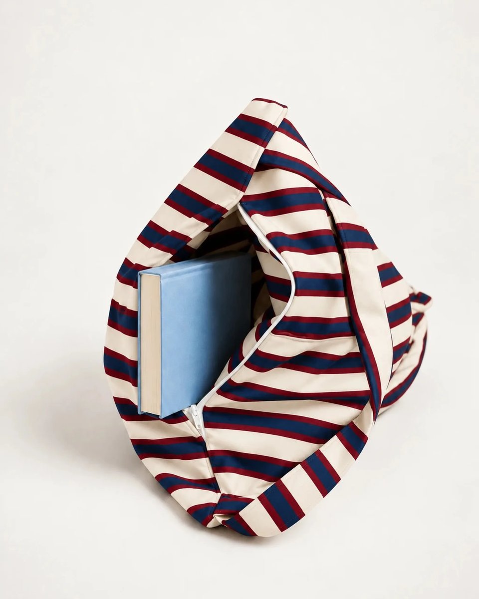 Open storage compartment of the Montauk backrest holding a hardcover book