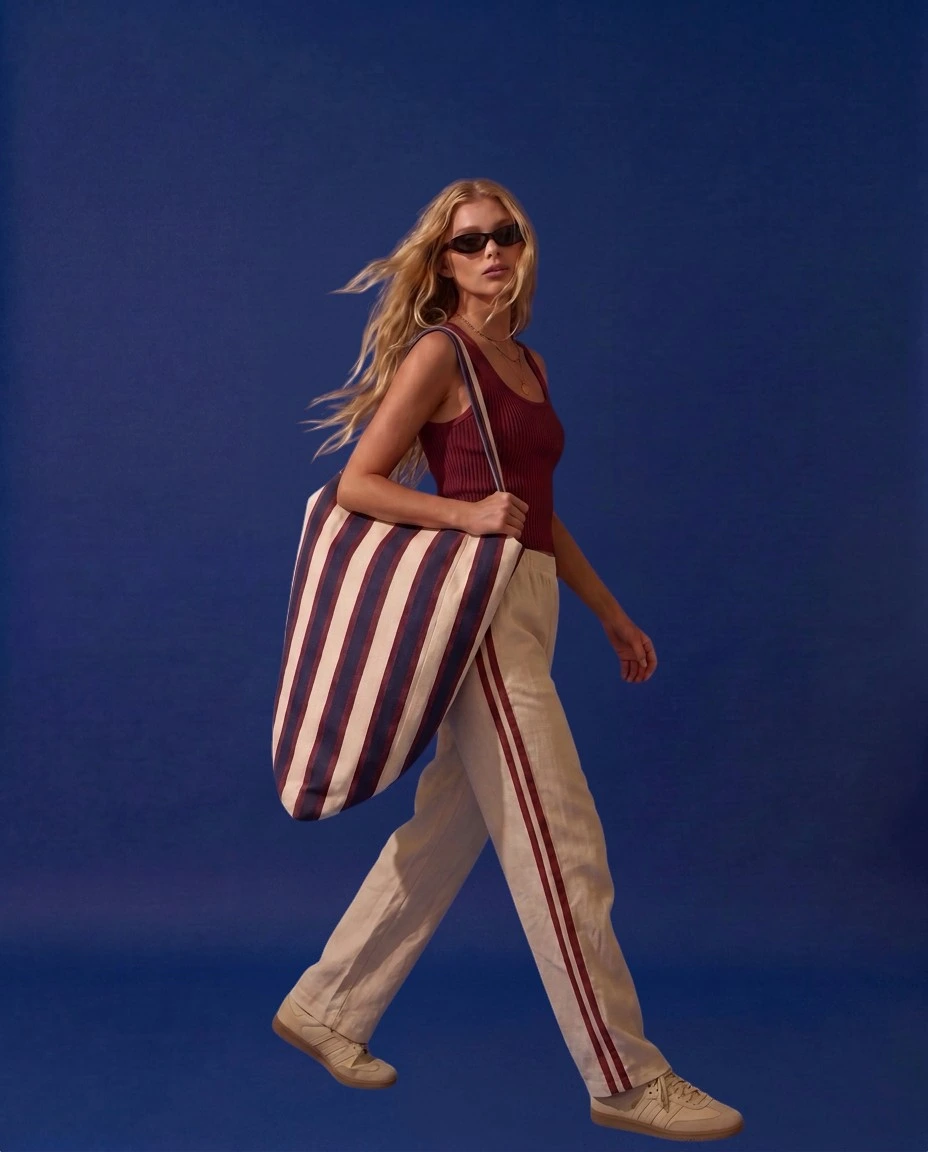 01 Carry — model walking through park with LIELOW bag over shoulder