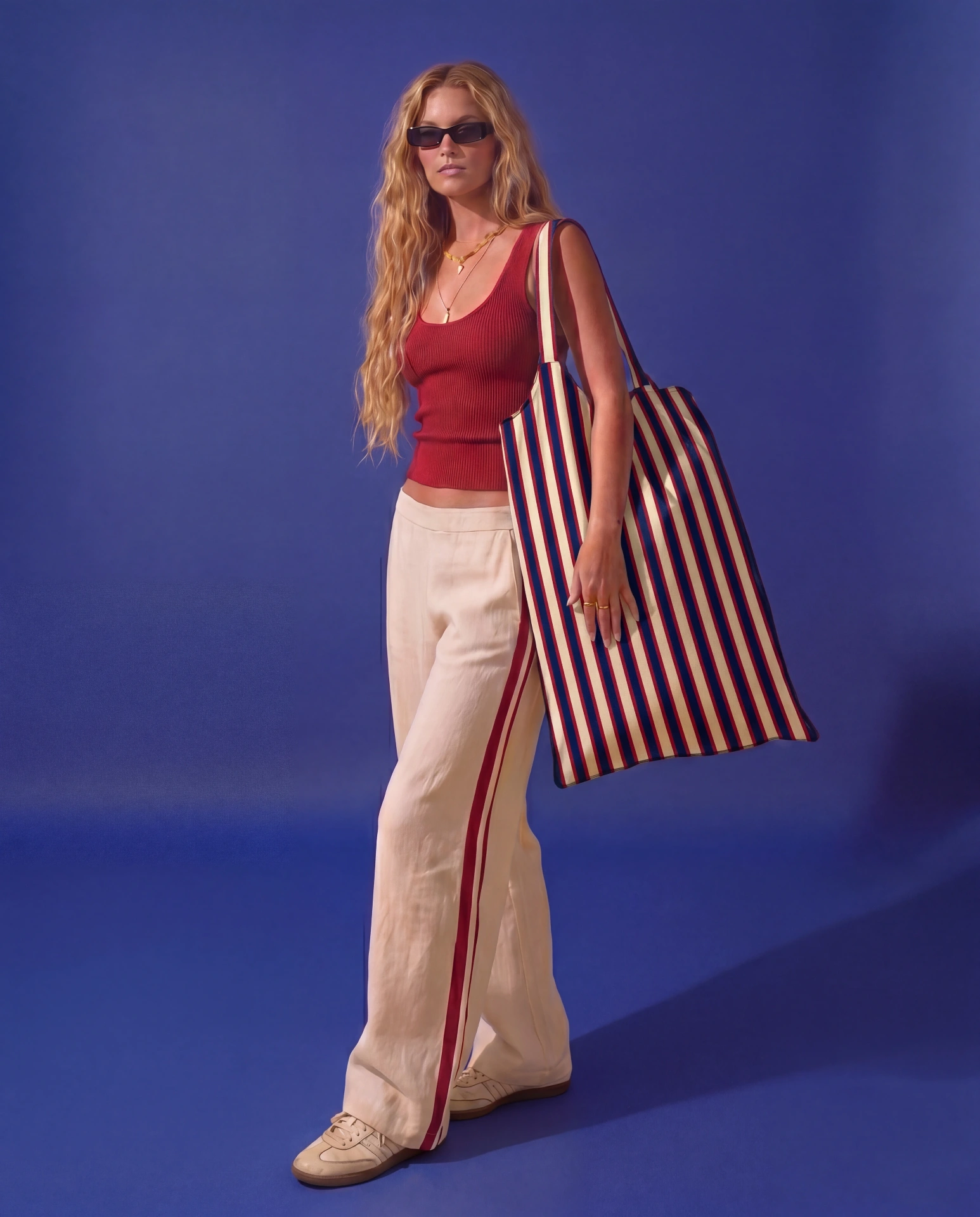 LIELOW Montauk — model carrying striped tote against blue backdrop