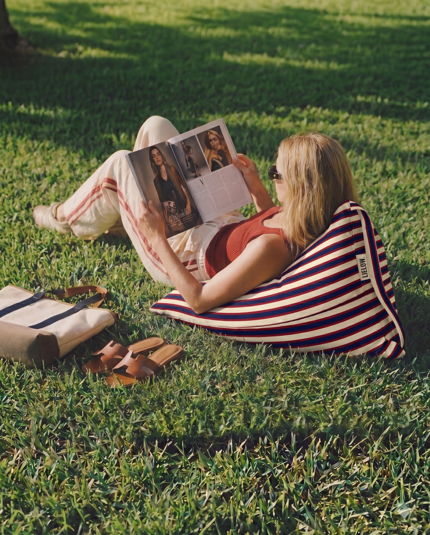 LIELOW Montauk — model reading magazine while lounging on bag-chair in park