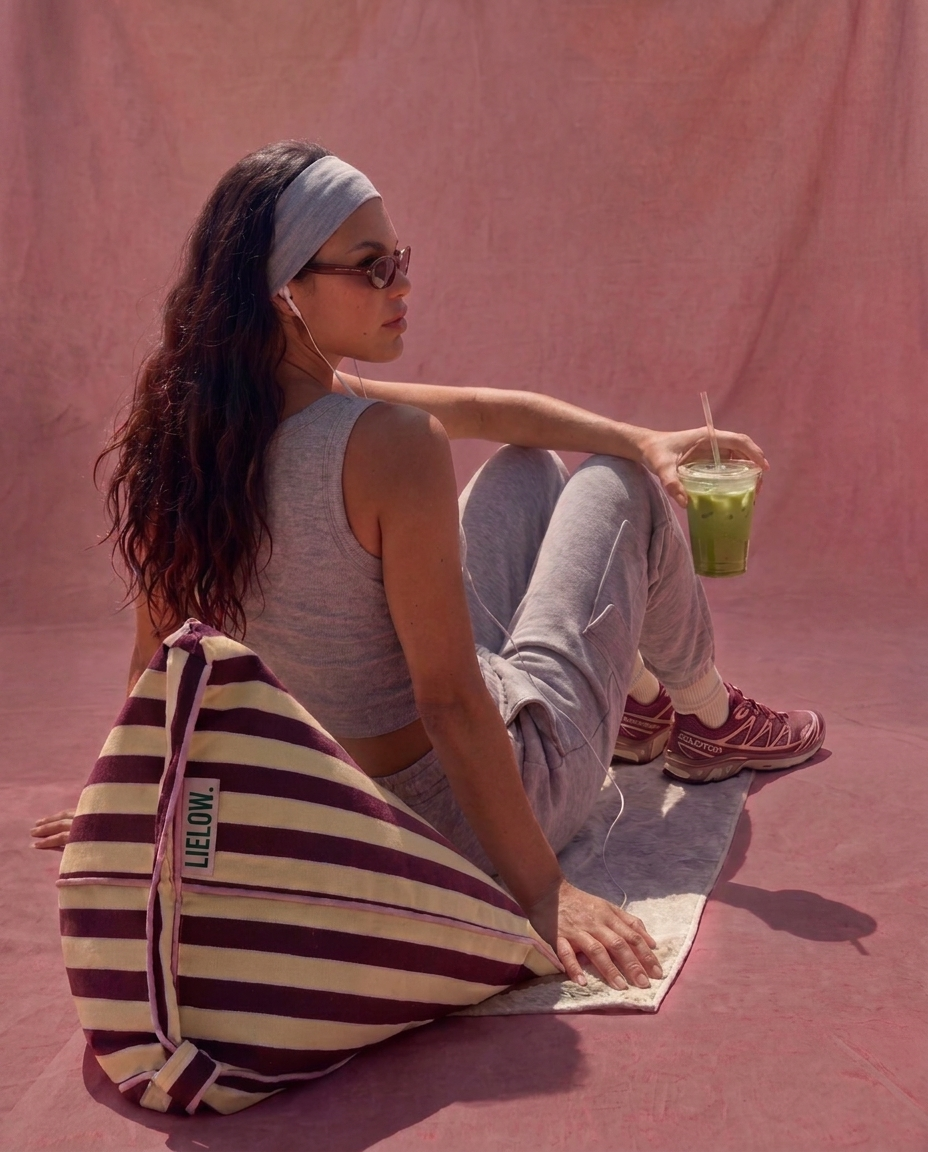Lielow Pier 55 — model seated with striped bag against pink backdrop